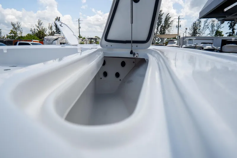 Slide: The Image of Open storage compartment on 2026 Tidewater 2410 Bay Max boat under a cloudy sky. - 34