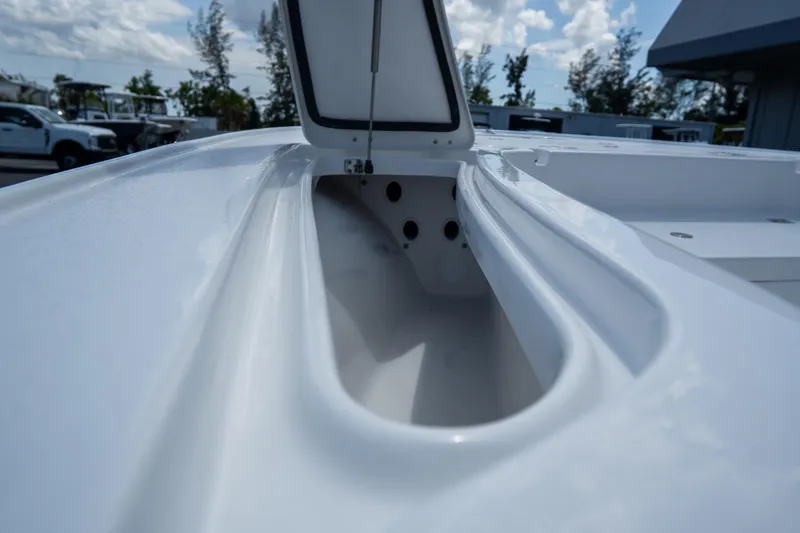 Slide: The Image of 2026 Tidewater 2410 Bay Max boat storage compartment, open lid, under a cloudy sky. - 35