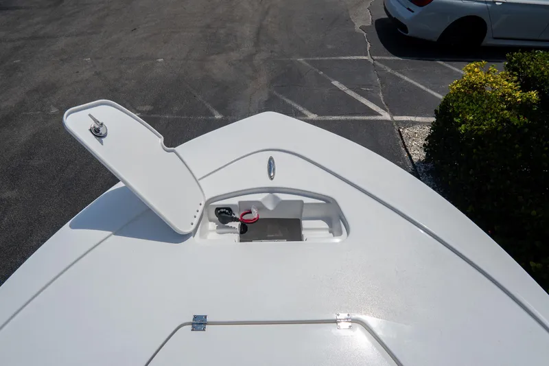 Slide: The Image of Bow storage compartment of 2026 Tidewater 2410 Bay Max boat, open lid, parking lot background. - 36