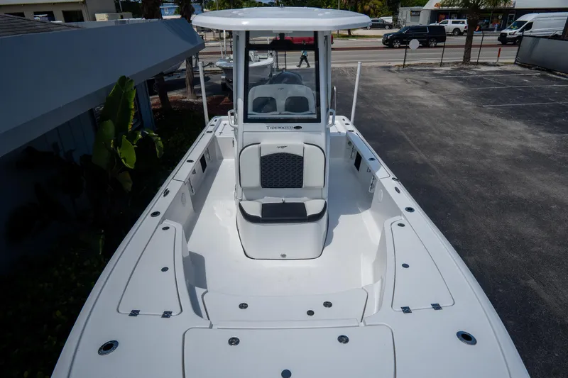 Slide: The Image of 2026 Tidewater 2410 Bay Max boat with spacious deck and seating, parked outdoors. - 38