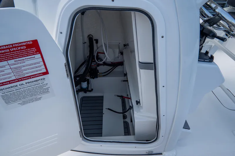 Slide: The Image of 2026 Tidewater 2410 Bay Max boat storage compartment with open door and visible wiring. - 41