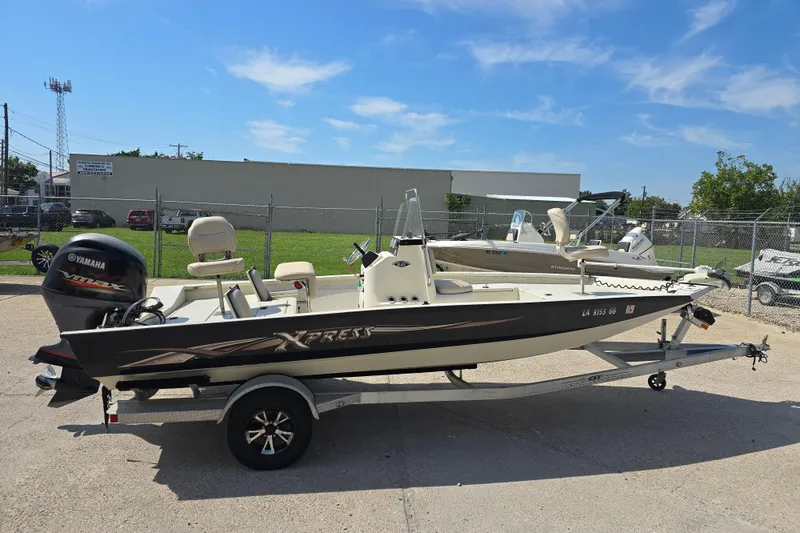 Slide: The Image of 2017 Xpress H20B Bay boat with Yamaha engine on trailer, parked outdoors. - 10