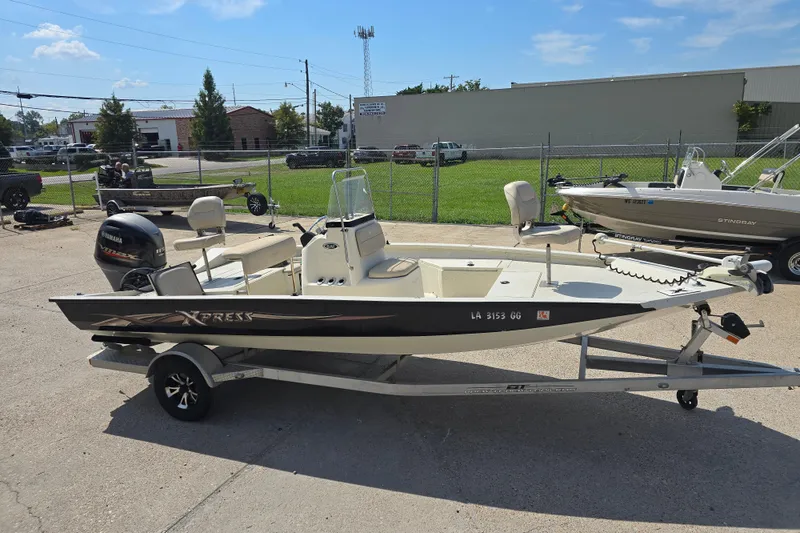 Slide: The Image of 2017 Xpress H20B Bay boat on trailer, parked outdoors under clear sky. - 15