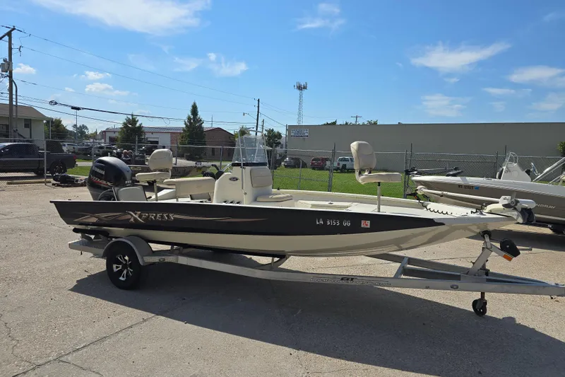 Slide: The Image of 2017 Xpress H20B Bay boat on trailer, parked outdoors under clear sky. - 9