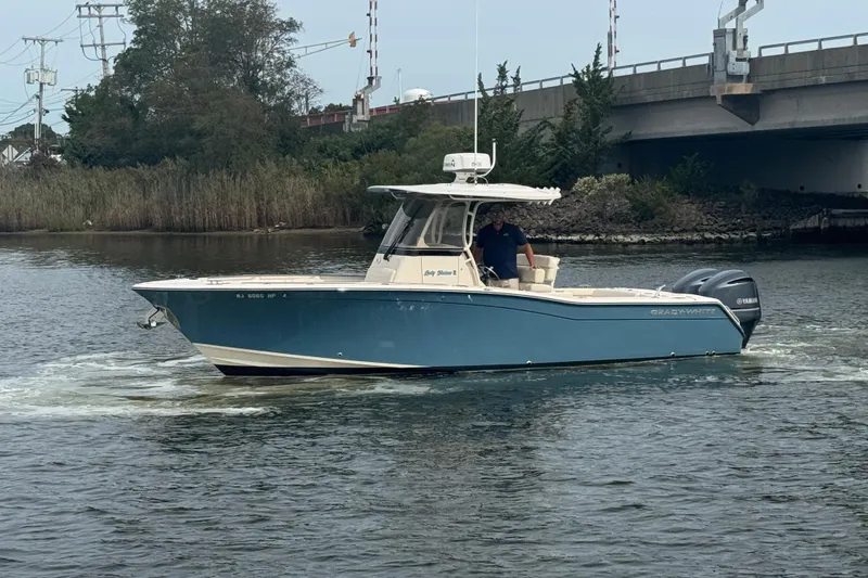 Slide: The Image of 2021 Grady-White Canyon 271 boat cruising on a calm river near a bridge. - 0