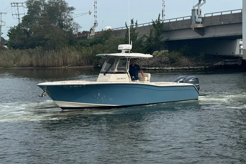Slide: The Image of 2021 Grady-White Canyon 271 boat cruising near a bridge in a scenic waterway. - 1