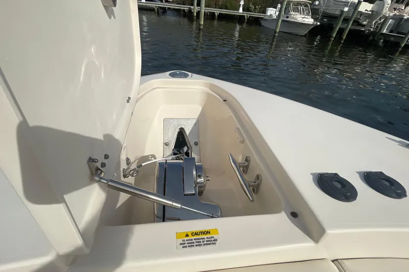 Slide: The Image of 2021 Grady-White Canyon 271 boat anchor compartment, open lid, docked at marina. - 11
