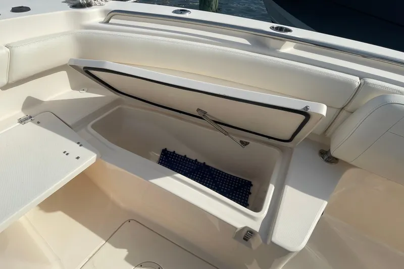 Slide: The Image of 2021 Grady-White Canyon 271 boat storage compartment with open lid, showcasing interior space. - 12