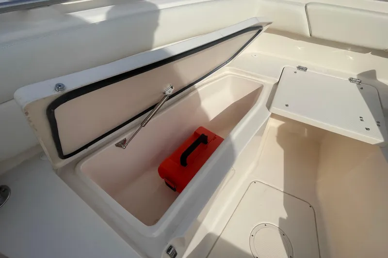 Slide: The Image of Open storage compartment on 2021 Grady-White Canyon 271 boat with red toolbox inside. - 15