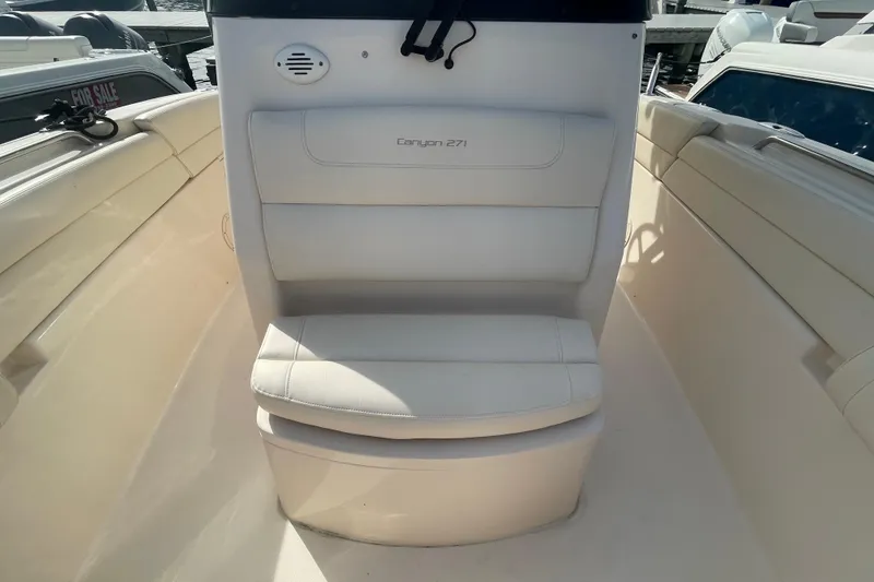 Slide: The Image of 2021 Grady-White Canyon 271 boat seat, white upholstery, docked with "For Sale" sign visible. - 18