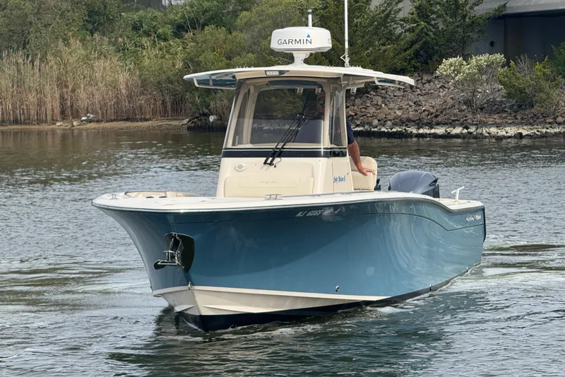 Slide: The Image of 2021 Grady-White Canyon 271 boat cruising on a calm river with lush greenery. - 3