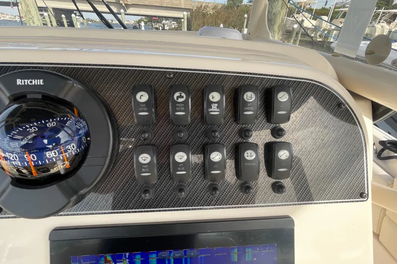 Slide: The Image of Control panel of 2021 Grady-White Canyon 271 boat with compass and switches. - 30