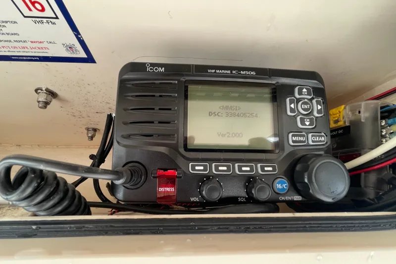 Slide: The Image of VHF marine radio on 2021 Grady-White Canyon 271 boat, featuring distress button and display. - 38
