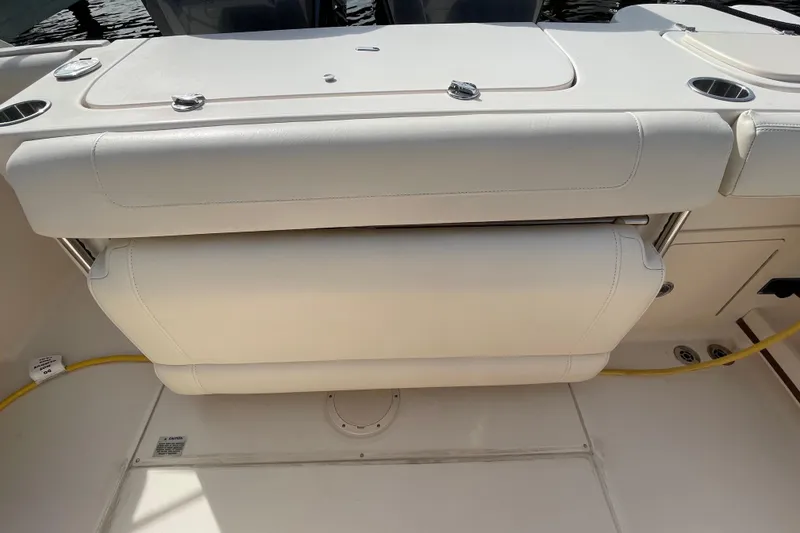 Slide: The Image of 2021 Grady-White Canyon 271 boat seating area with white upholstery and cup holders. - 40