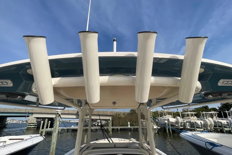 Slide: The Image of 2021 Grady-White Canyon 271 boat with rod holders, docked under a clear blue sky. - 43