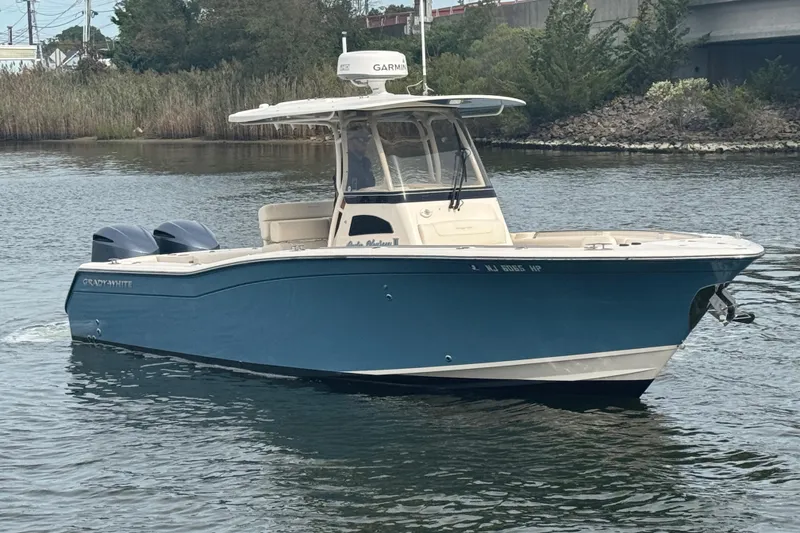 Slide: The Image of 2021 Grady-White Canyon 271 boat on calm water, featuring a sleek blue hull. - 6