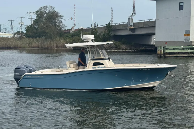 Slide: The Image of 2021 Grady-White Canyon 271 boat on water, featuring Yamaha engine, near a bridge. - 8
