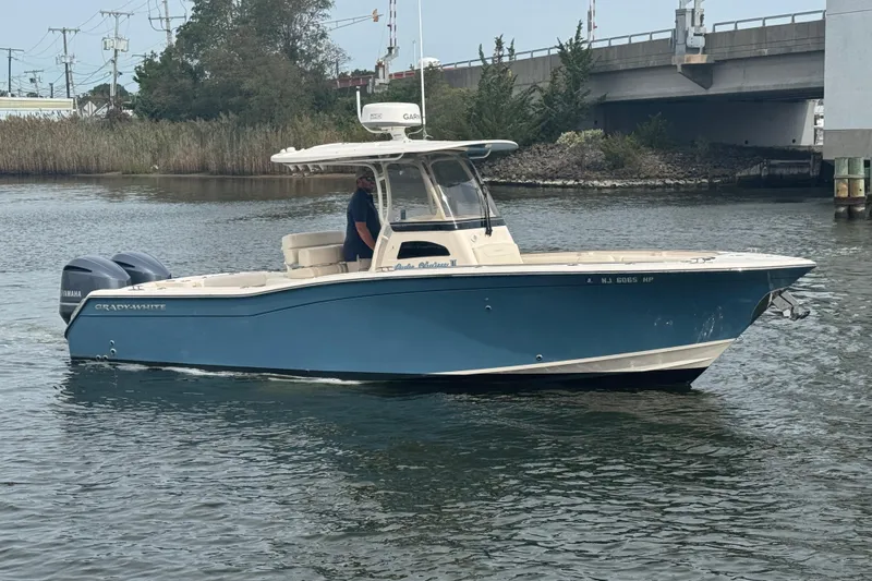 Slide: The Image of 2021 Grady-White Canyon 271 boat on water near a bridge, featuring dual Yamaha engines. - 9