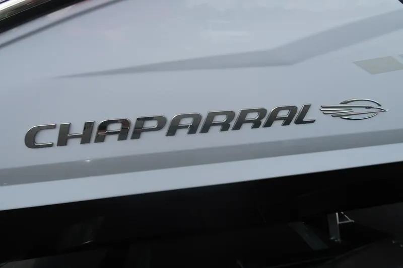 Slide: The Image of 2026 Chaparral 23 SSi trailer with dual black alloy wheels on asphalt. - 15