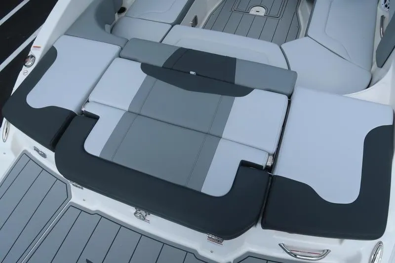 Slide: The Image of 2026 Chaparral 23 SSi boat interior with storage compartment and cushioned seating. - 23