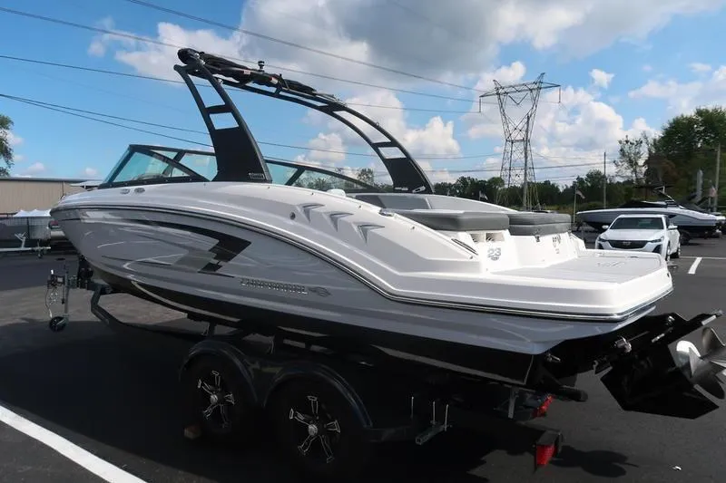 Slide: The Image of 2026 Chaparral 23 SSi boat, front view, parked outdoors under a blue sky. - 7