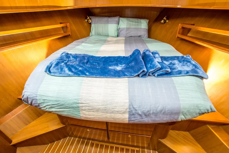 Slide: The Image of Cozy cabin interior of 2008 North Pacific 43 Pilothouse with striped bedding and wooden finish. - 16