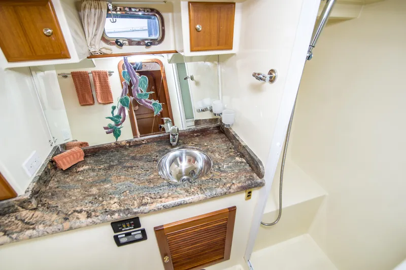 Slide: The Image of 2008 North Pacific 43 Pilothouse bathroom with granite countertop and stainless steel sink. - 17