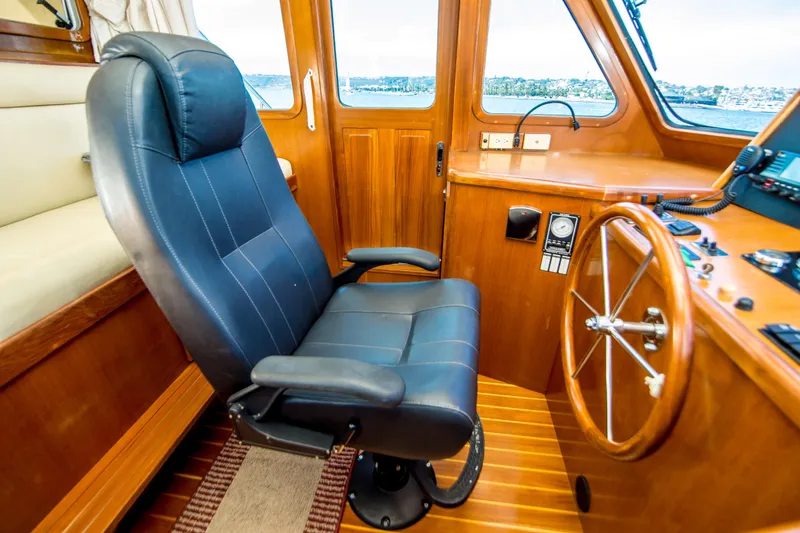 Slide: The Image of Pilothouse interior of 2008 North Pacific 43, featuring captain's chair and steering wheel. - 23