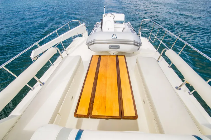 Slide: The Image of 2008 North Pacific 43 Pilothouse yacht deck with wooden table and inflatable boat. - 29