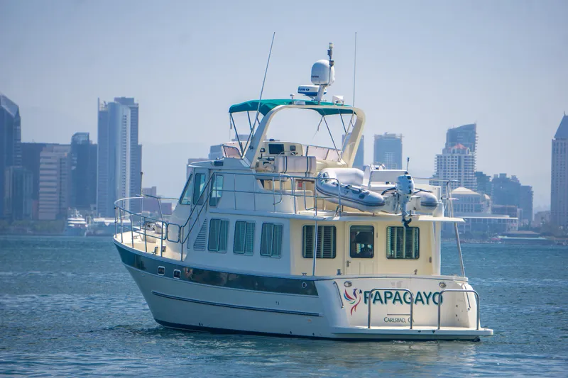 Slide: The Image of 2008 North Pacific 43 Pilothouse yacht on water with city skyline backdrop. - 5