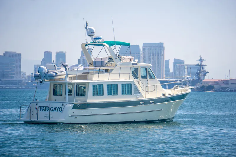 Slide: The Image of 2008 North Pacific 43 Pilothouse yacht on water with city skyline background. - 6