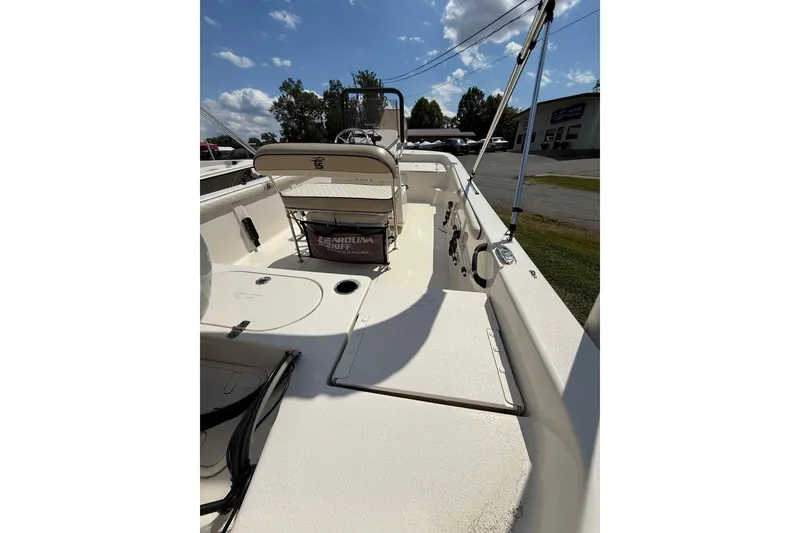Slide: The Image of 2020 Carolina Skiff 19 LS boat interior with seating and storage, under a clear blue sky. - 15
