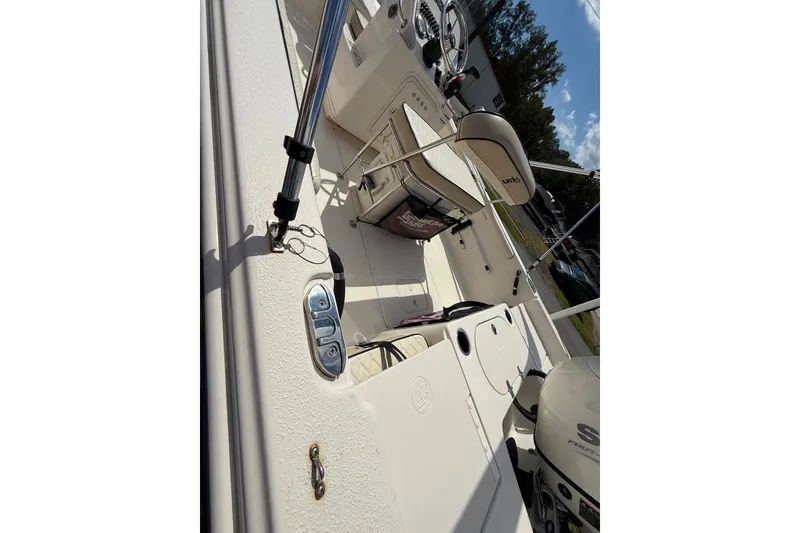 Slide: The Image of 2020 Carolina Skiff 19 LS boat interior with seating and controls, under sunny sky. - 2