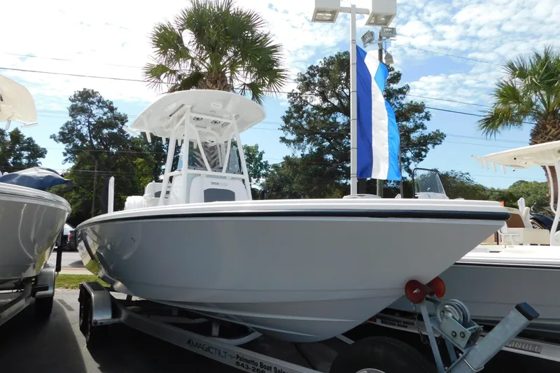 The Image of 2026 Pathfinder 2400 TRS boat on trailer, displayed outdoors with palm trees and blue sky. - 0