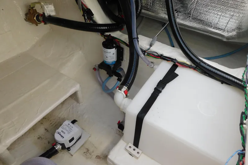 Slide: The Image of Interior view of a 2026 Pathfinder 2400 TRS boat showing plumbing and wiring components. - 24
