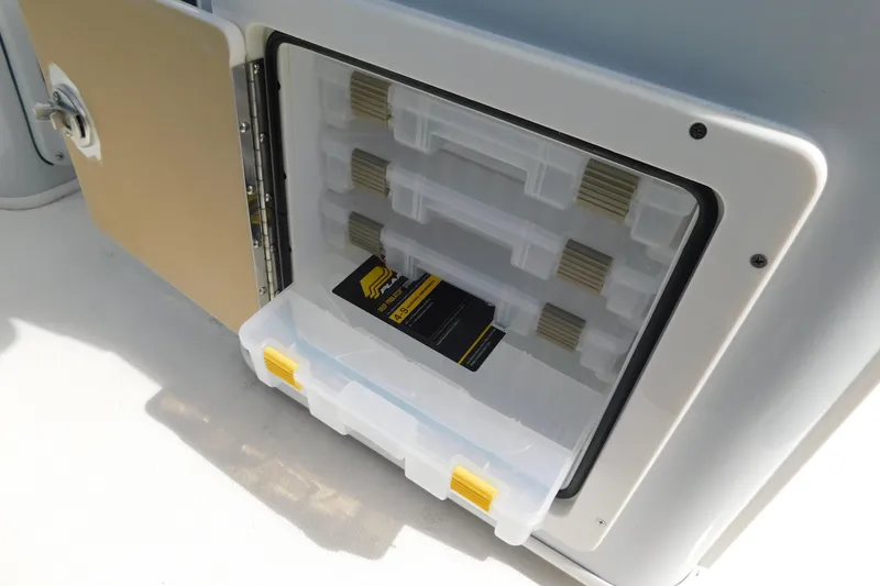 Slide: The Image of Open storage compartment on 2026 Pathfinder 2400 TRS boat with organized tackle boxes. - 26