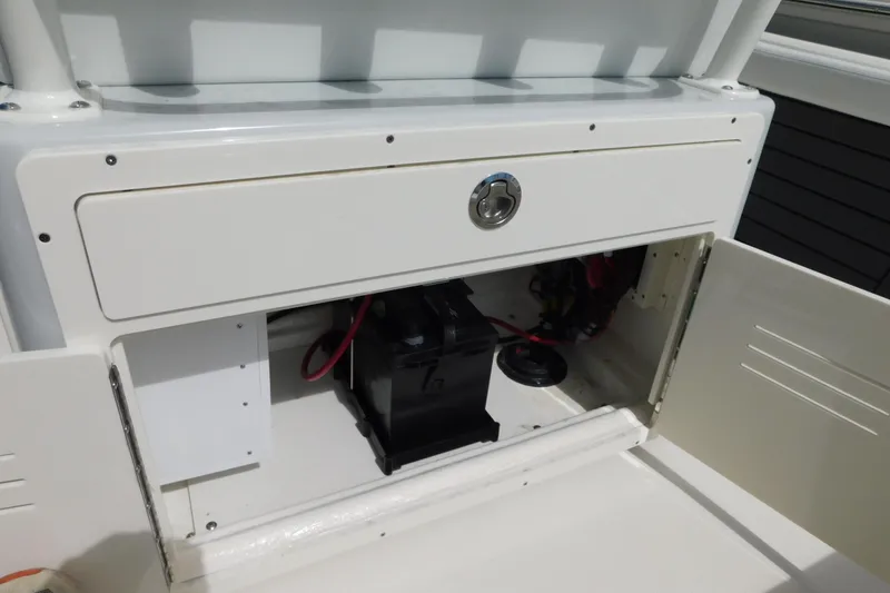 Slide: The Image of 2026 Pathfinder 2400 TRS boat storage compartment with battery and wiring. - 27