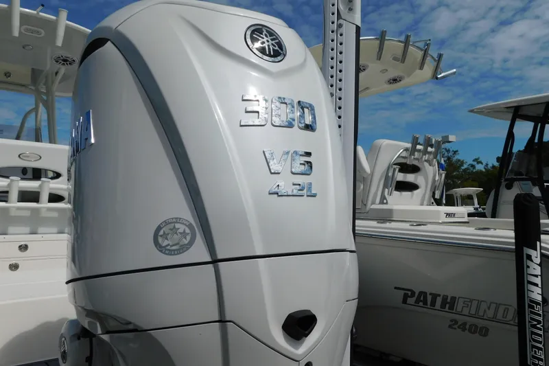 Slide: The Image of 2026 Pathfinder 2400 TRS boat with Yamaha 300 V6 4.2L engine, docked under blue sky. - 46