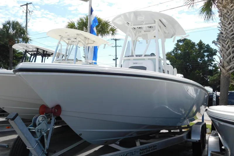 Slide: The Image of 2026 Pathfinder 2400 TRS boat on trailer, displayed outdoors with palm trees. - 49