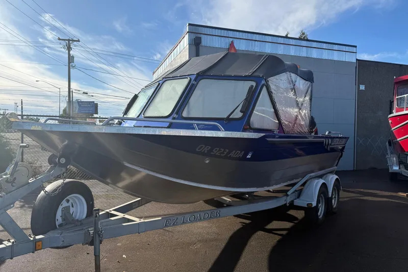 The Image of 2006 Custom Weld Cobra OB boat on trailer, parked outdoors under clear sky. - 1