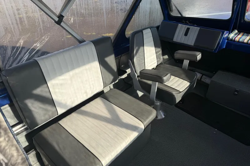 Slide: The Image of 2006 Custom Weld Cobra OB boat interior with gray seating and windows. - 11