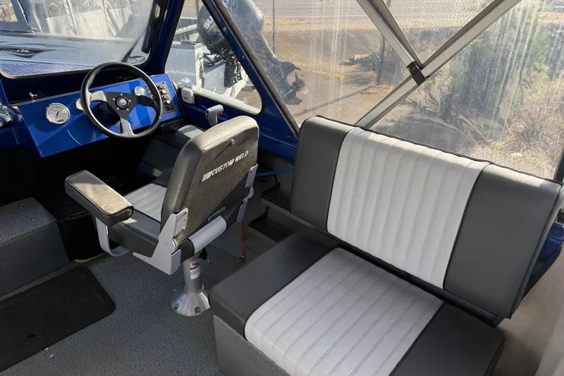 Slide: The Image of 2006 Custom Weld Cobra OB boat interior with steering wheel and seating. - 12