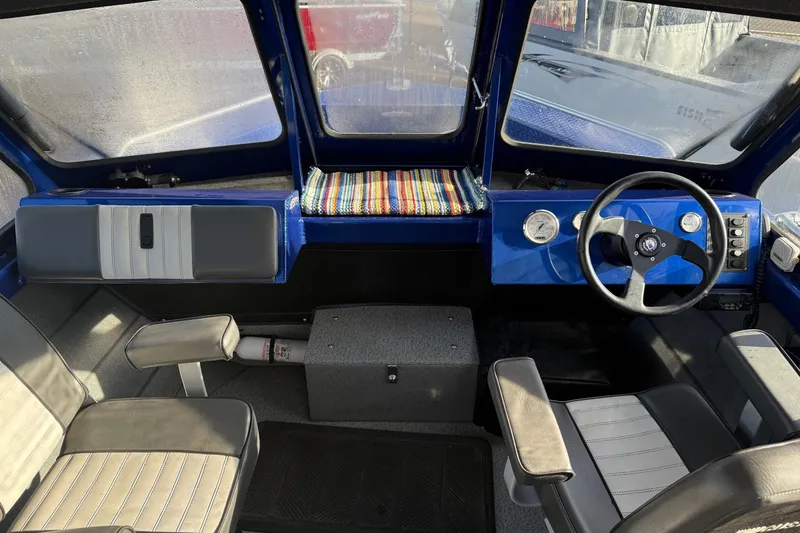 Slide: The Image of 2006 Custom Weld Cobra OB boat interior with steering wheel and seating. - 13