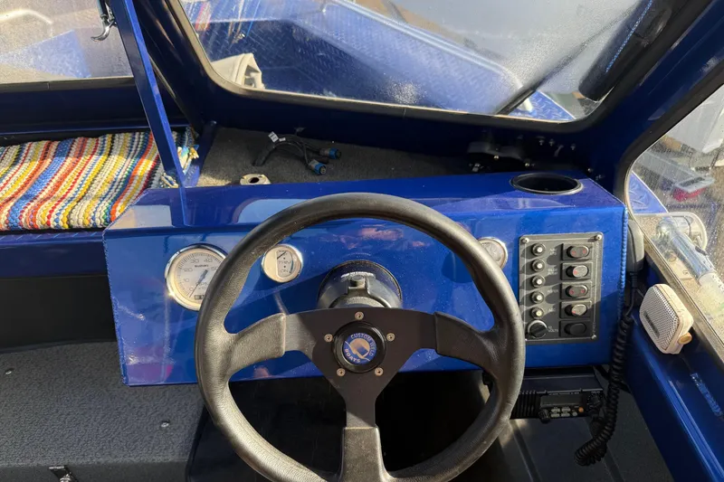 Slide: The Image of 2006 Custom Weld Cobra OB boat dashboard with steering wheel and control panel. - 16