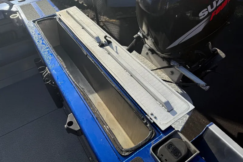 Slide: The Image of 2006 Custom Weld Cobra OB boat with open storage compartment and Suzuki outboard motor. - 8