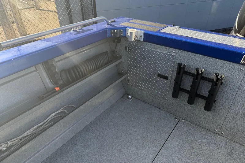 Slide: The Image of 2006 Custom Weld Cobra OB boat interior with rod holders and storage compartments. - 9