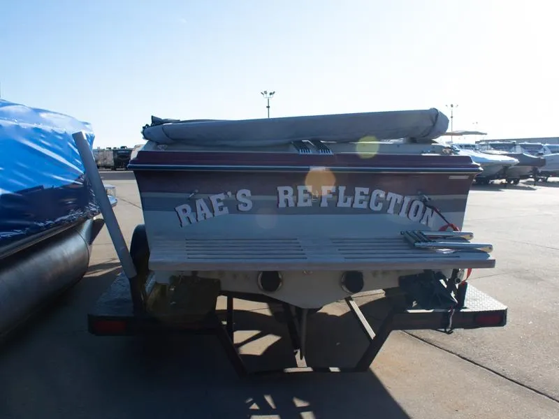Slide: The Image of 1987 Baja 190 Sport boat, rear view, with "Rae's Reflection" text, parked outdoors. - 4