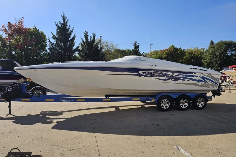 Slide: The Image of 2004 Baja 29 Outlaw speedboat on trailer, parked outdoors, showcasing sleek design and vibrant graphics. - 17