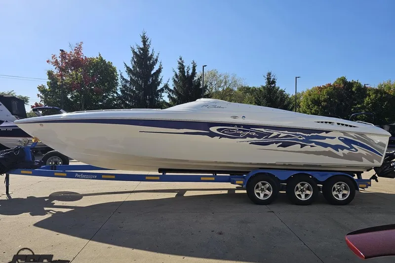 Slide: The Image of 2004 Baja 29 Outlaw speedboat on trailer, parked outdoors under clear blue sky. - 18