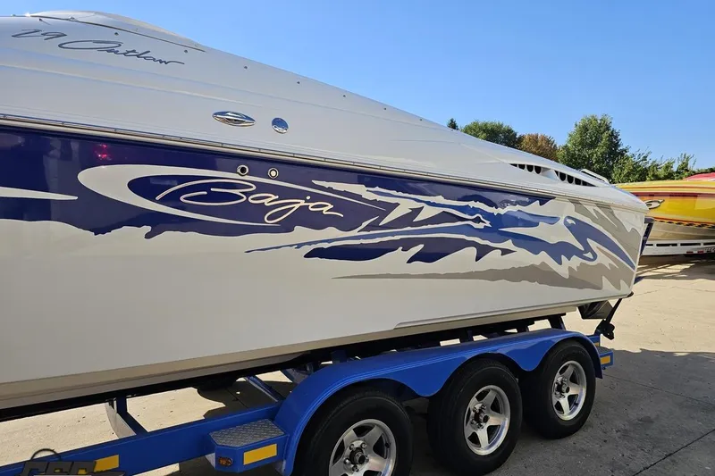 Slide: The Image of 2004 Baja 29 Outlaw boat with blue and white graphics on a trailer. - 19